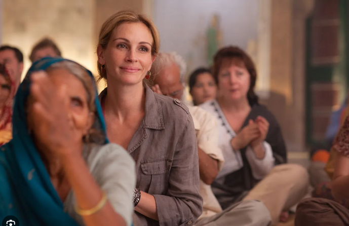 An ashram courtyard at dawn — Liz meditating cross-legged among other students, from the film Eat, Pray, Love (2010)