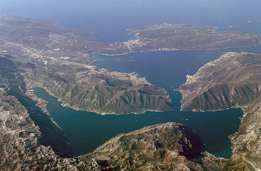 Aerial view of Kotor old town with red-tiled roofs against the deep blue Bay of Kotor